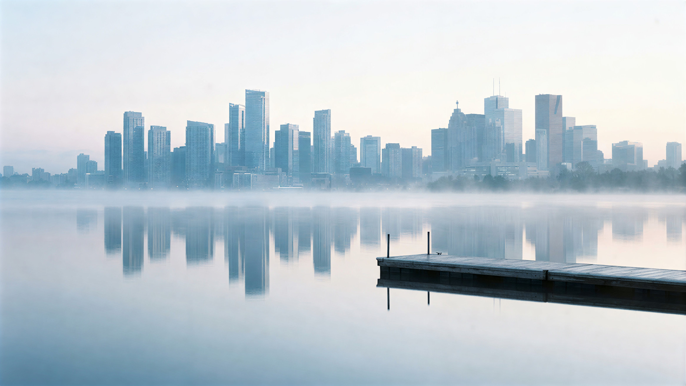A quiet lake and the city skyline beyond